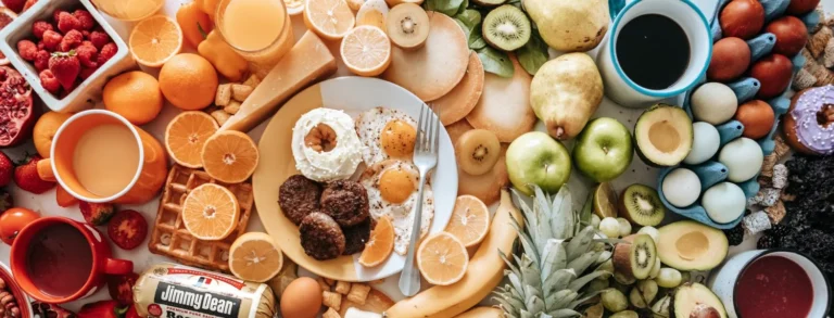 Top down view of a table filled with healthy foods arranged in rainbow color order from left to right