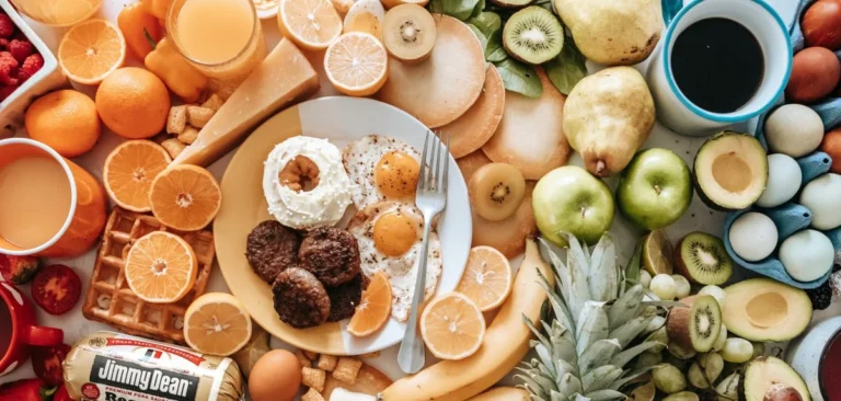 Top down view of a table filled with healthy foods arranged in rainbow color order from left to right