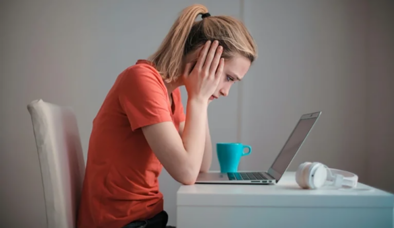 Distraught woman looking at her laptop